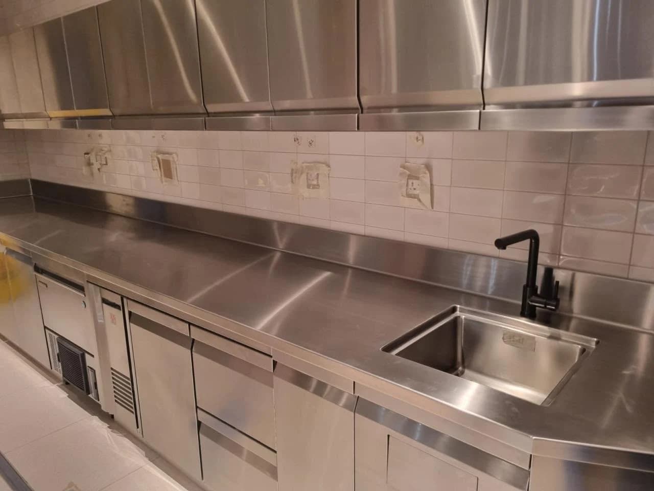 Stainless steel kitchen counters, storage and an integrated sink at Al Khoory Sky Garden Hotel